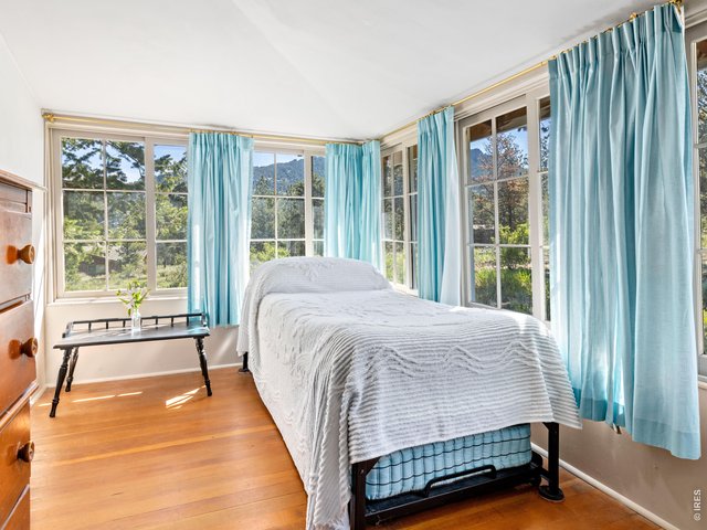 Property Photo 17 Bedroom one of two with large antique 6 pane windows capturing serene views of the trees and surrounding hills
