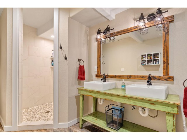 Property Photo 25 Stunning farmhouse-inspired primary bathroom featuring a spacious double vanity and an expansive walk-in shower.