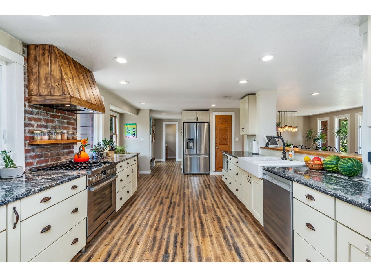 This expansive kitchen features updated cabinetry, granite countertops, farmhouse sink, pantry, new gas range, new dishwasher, and ample prep space.