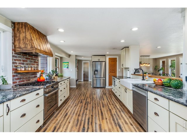 Property Photo 13 This expansive kitchen features updated cabinetry, granite countertops, farmhouse sink, pantry, new gas range, new dishwasher, and ample prep space.