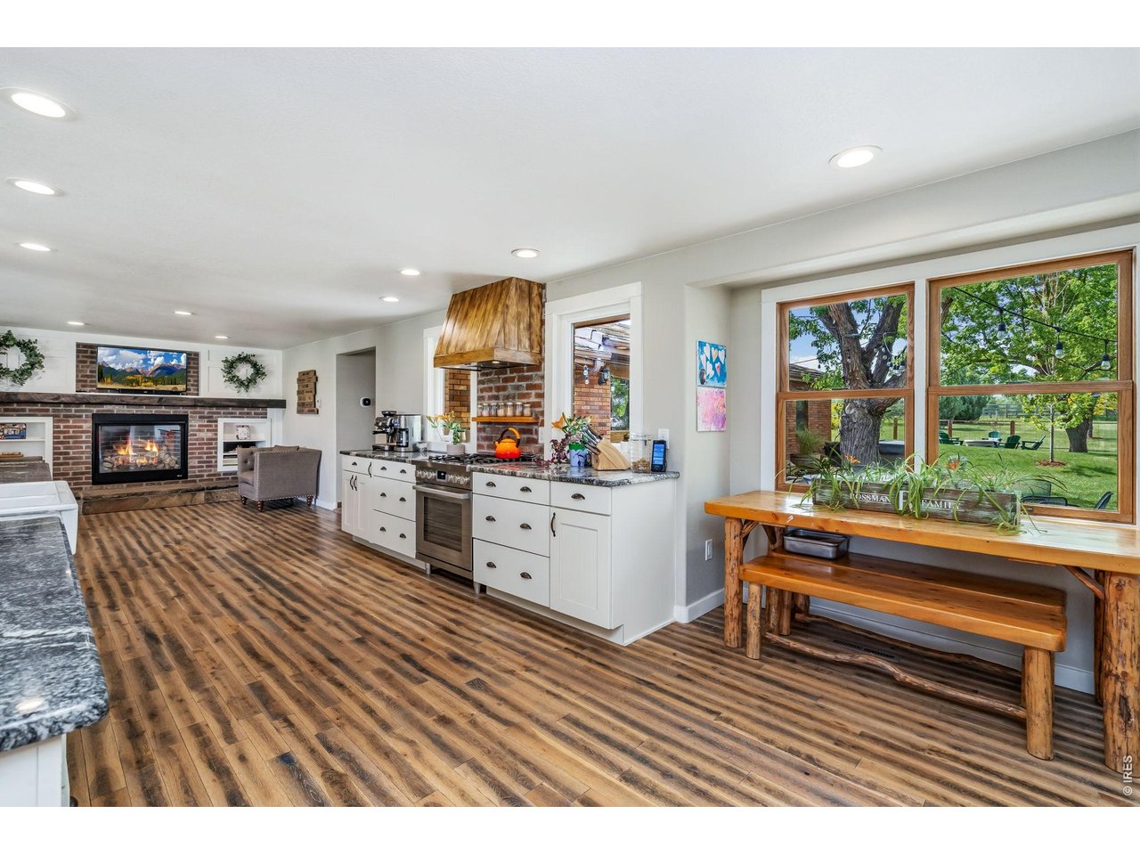 Spacious kitchen featuring a cozy fireplace nook on one end and a dedicated eat-in dining area on the other.