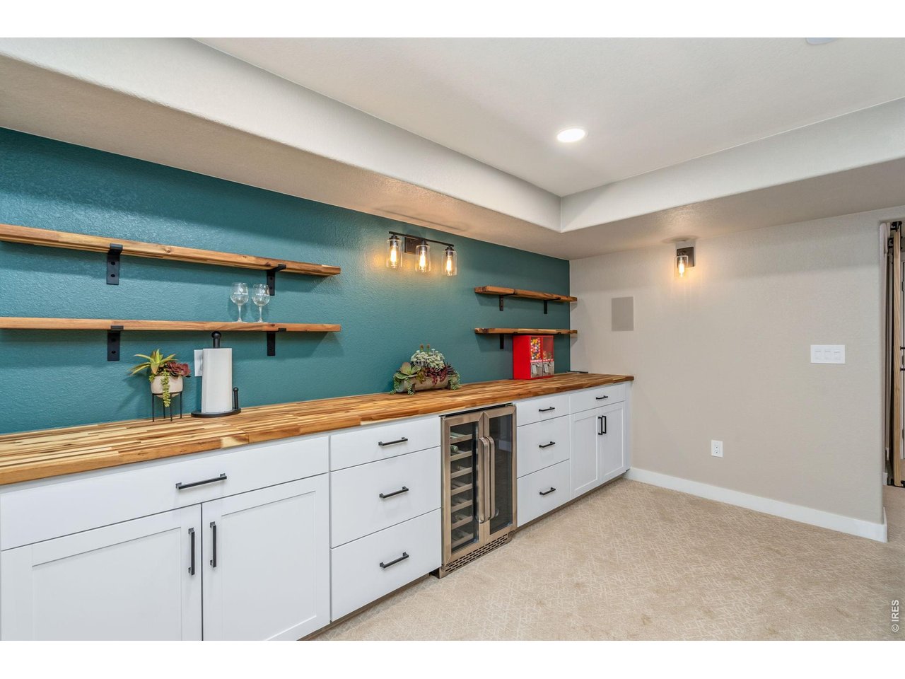 The spacious basement recreation room features a built-in bar and beverage fridge, perfect for entertaining and hosting game day watch parties