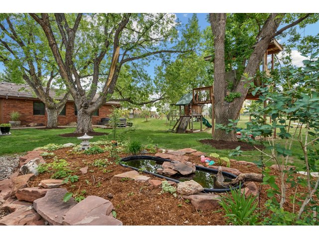 Property Photo 45 Enjoy the outdoors in this expansive backyard, featuring a water feature, play set & spacious lawn shaded by beautiful, mature trees.