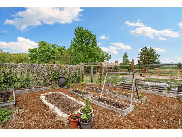 Property Photo 46 Fenced garden area - ready for growing veggies, featuring planting beds and optimal southern exposure for sunlight.