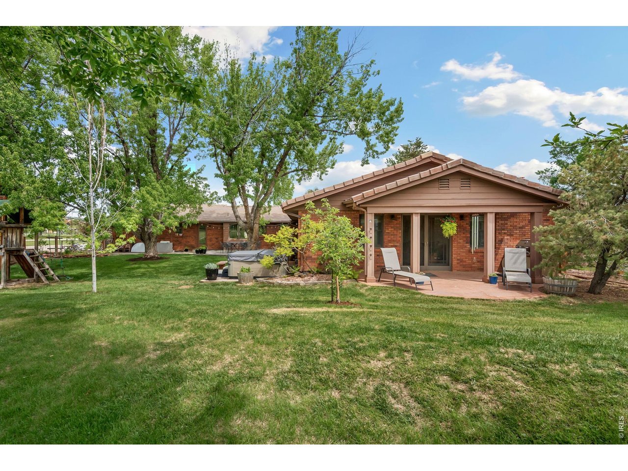 Gorgeous back view of home, yard, payset, hot tub and south patio