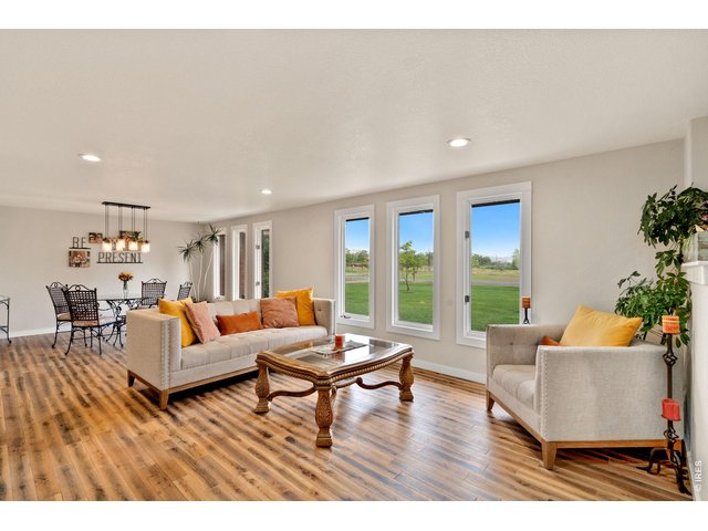 Property Photo 9 Living and dining area featuring large windows with scenic views of the open landscape and the Devil's Backbone Mountains in the background.
