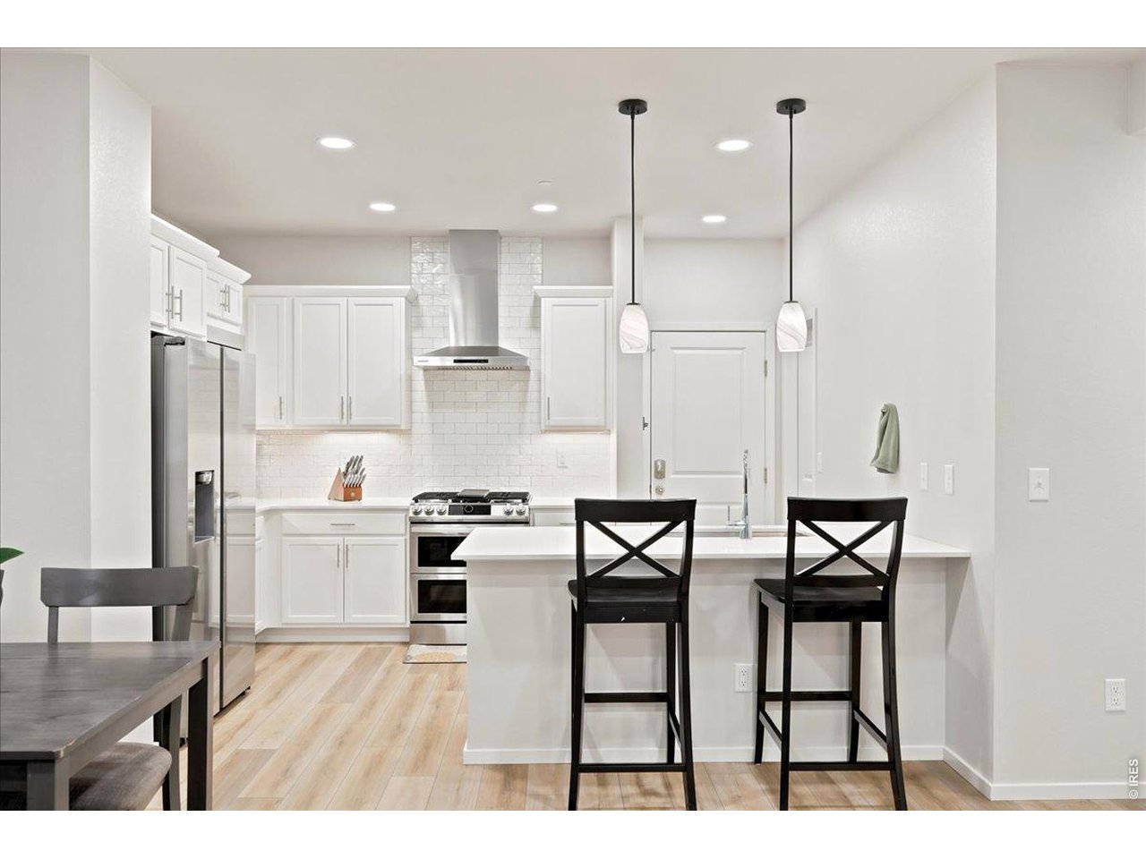 Property Photo 4 Chef's kitchen with white cabinetry, stainless appliances, and a gas range.
