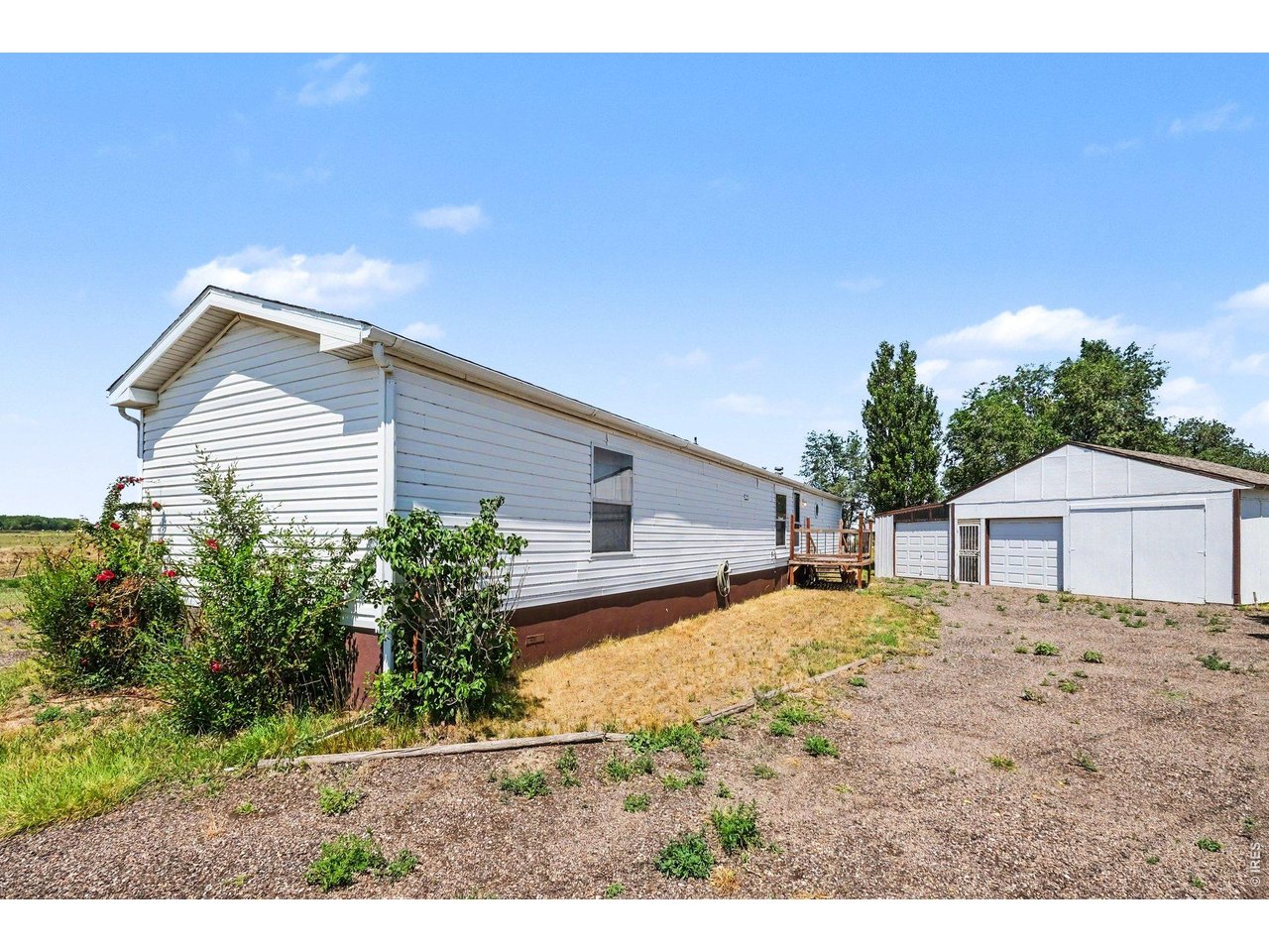 Property Photo 1 Permanently affixed, with 3-car outbuilding, sits on fully fenced .38 acres.