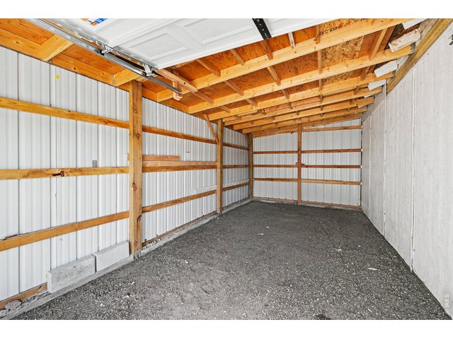 Property Photo 4 Storage section of outbuilding/garage, completely separated; previously used as workshop area.Two additional garage bays; one used for boat. Garage has electric.