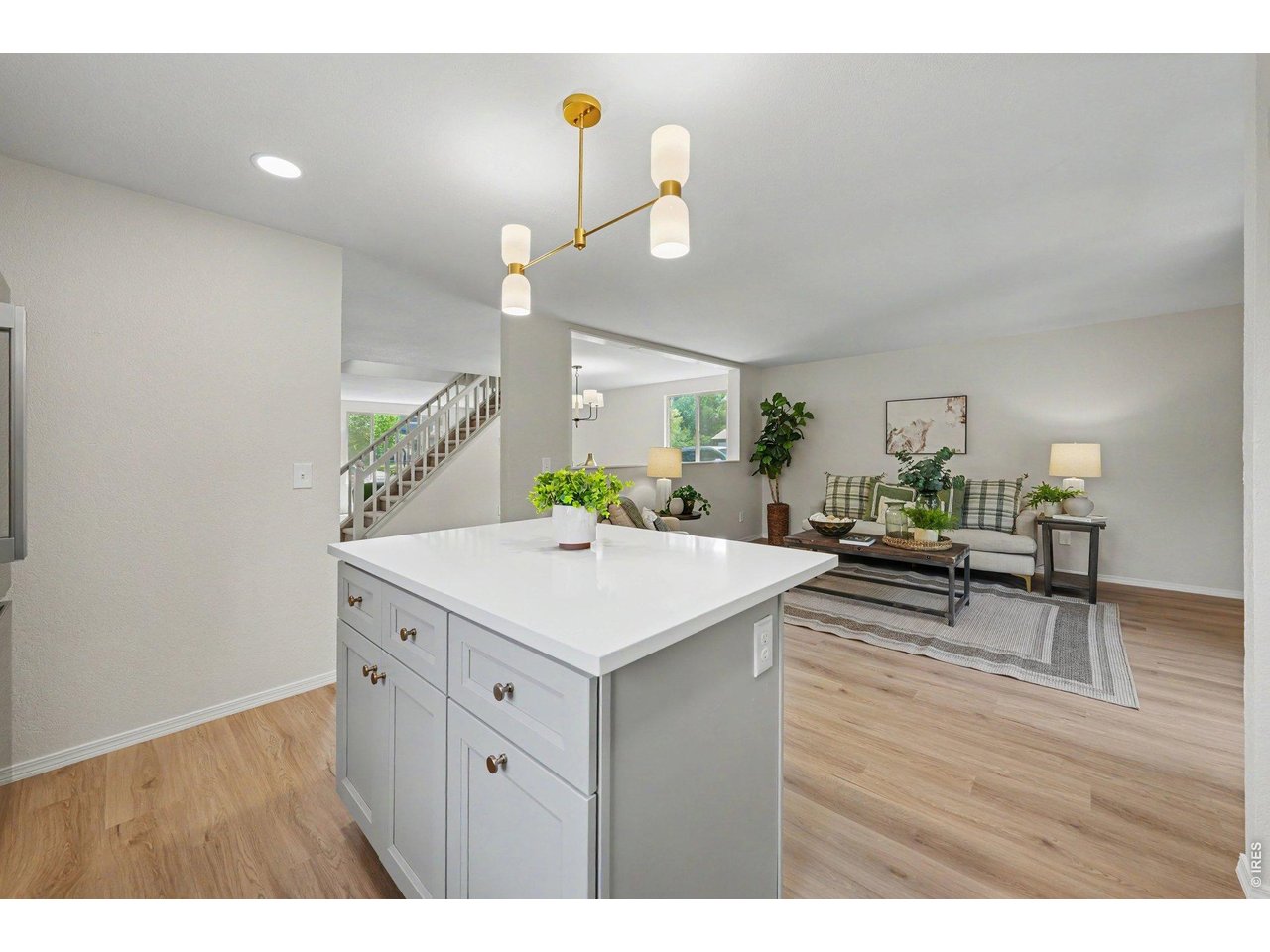 Property Photo 12 Kitchen island with its light stone countertop and updated cabinetry looking out into the open family room.