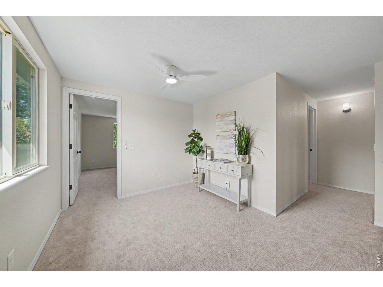 Property Photo 15 Bright upper-level landing featuring fresh carpeting, a modern ceiling fan, and elegant staging.