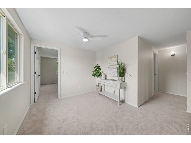 Property Photo 15 Bright upper-level landing featuring fresh carpeting, a modern ceiling fan, and elegant staging.