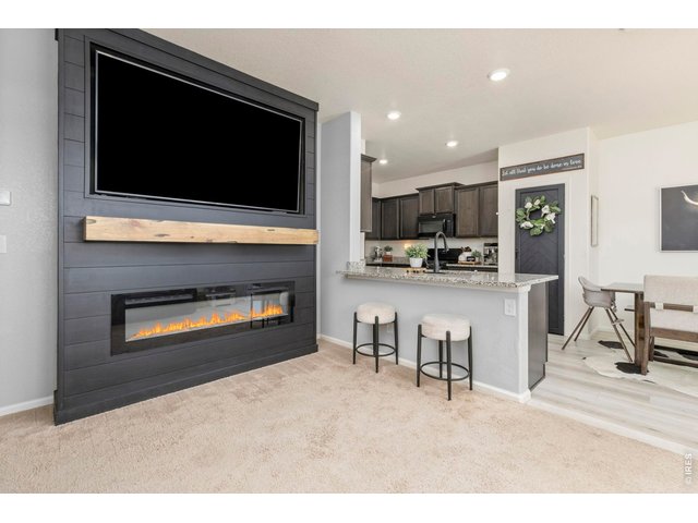 Property Photo 2 Featuring a fireplace with a custom mantle, designer accent walls, and quality upgrades throughout, this home offers standout character and modern comfort.