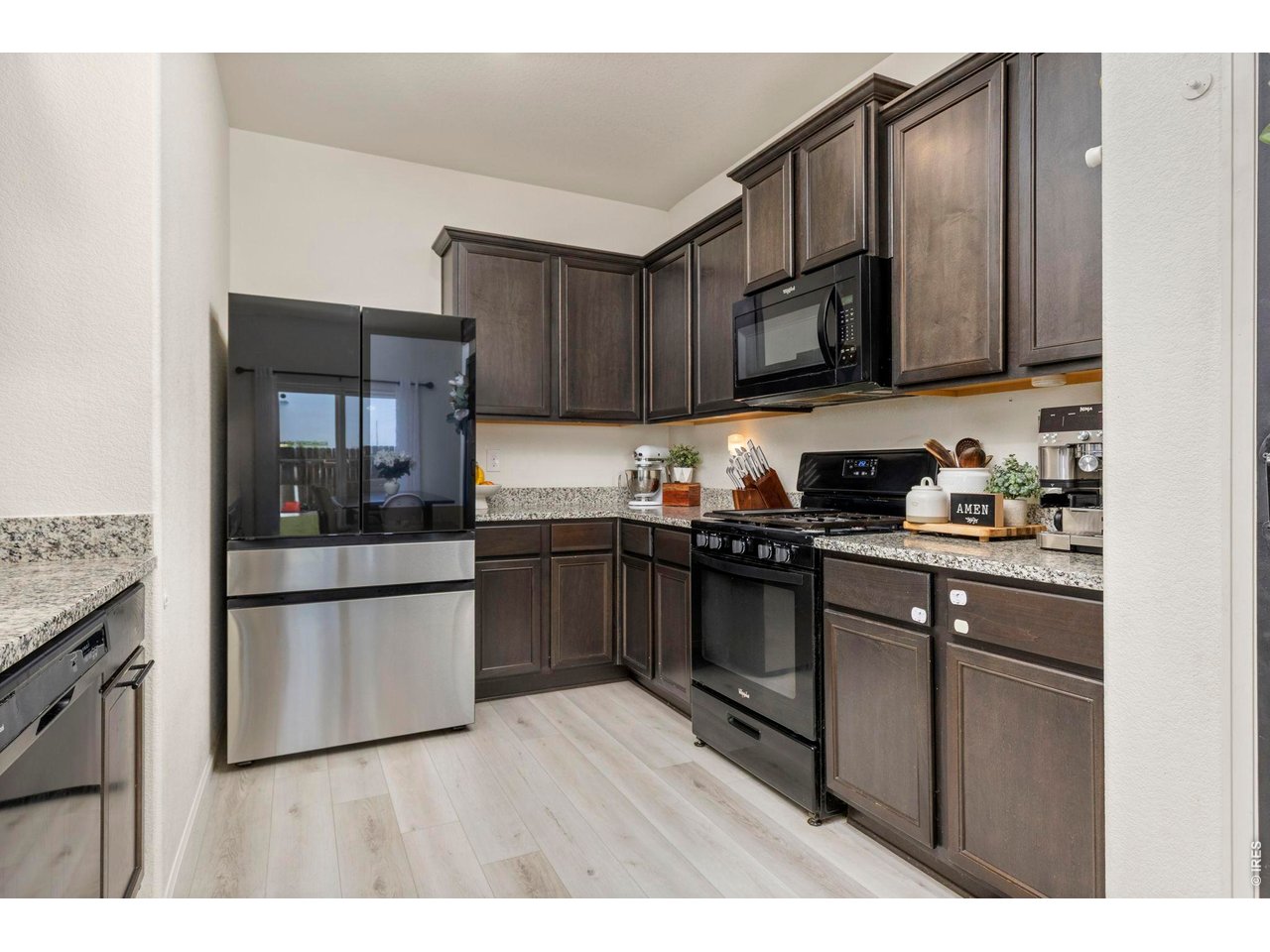 Property Photo 9 The kitchen features granite countertops, ample Cityscape cabinetry, a large pantry with a custom accent door, breakfast bar seating, and a generous dining area.