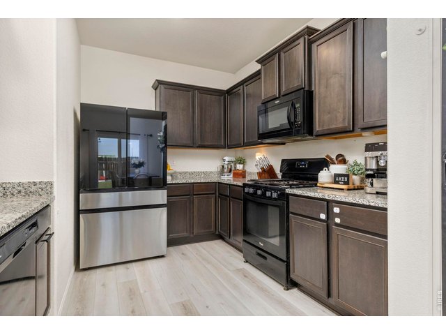 Property Photo 9 The kitchen features granite countertops, ample Cityscape cabinetry, a large pantry with a custom accent door, breakfast bar seating, and a generous dining area.