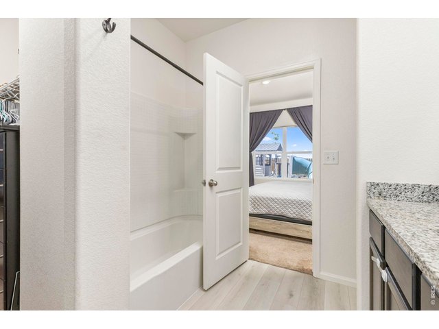 Property Photo 15 The primary suite includes a full en-suite bathroom with granite countertops, a board and batten accent wall, and a large walk-in closet.
