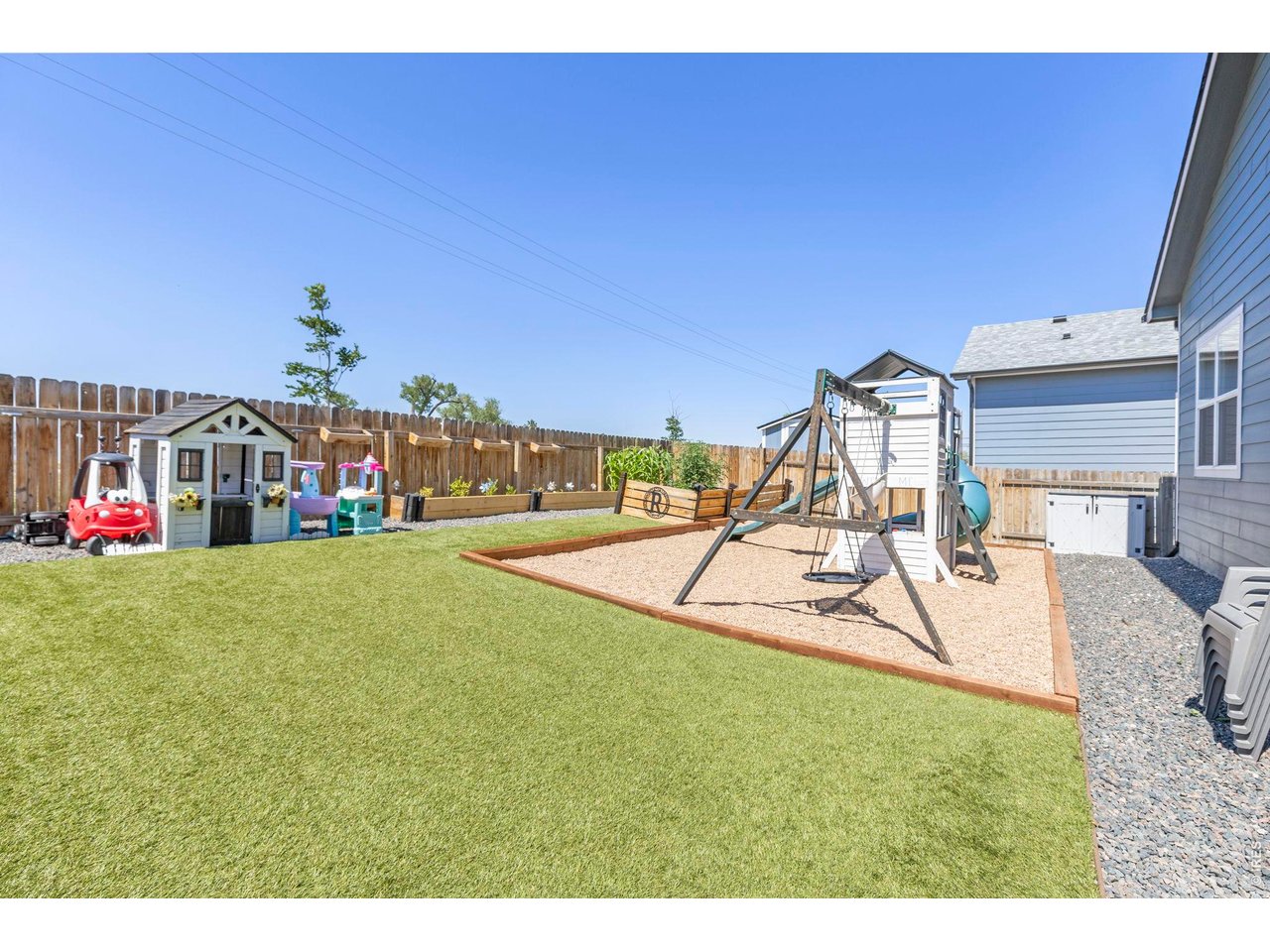 Property Photo 23 Outside, enjoy a low-maintenance backyard with custom garden beds and artificial turf, along with a front yard sprinkler system.