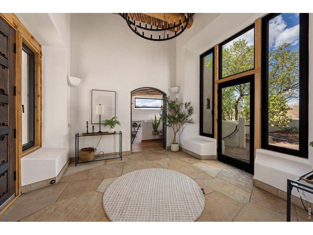 Property Photo 5 A light-filled foyer with soaring ceilings and handcrafted details opens seamlessly to a private courtyard, creating an inviting indoor-outdoor entry experience.