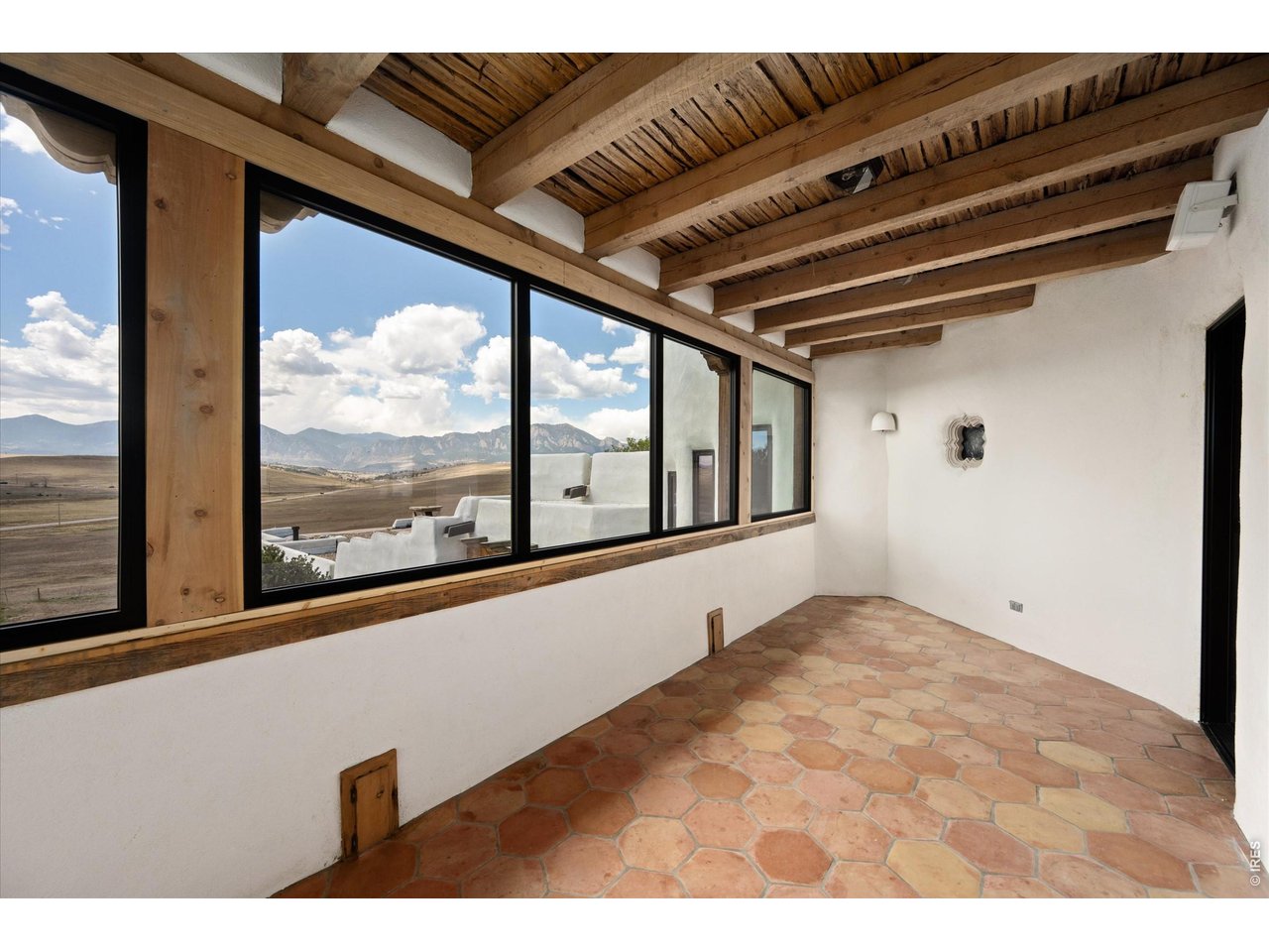 Property Photo 22 A three-season attached porch with a kiva fireplace offers a cozy extension of the home, perfectly positioned off the living room and kitchen to take in sweeping west-facing mountain views. 25 x 10