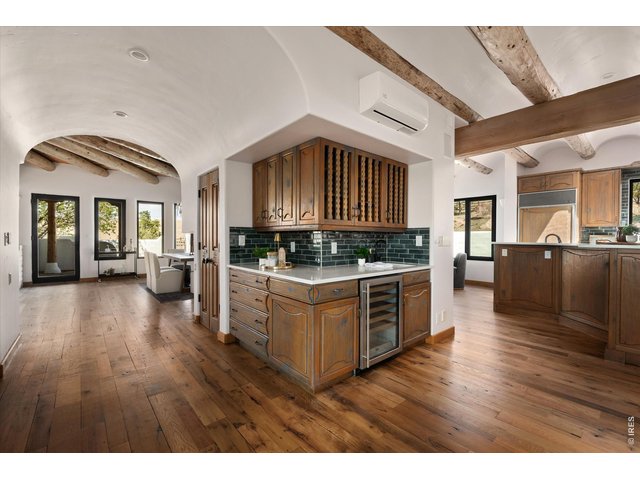 Property Photo 12 A seamless flow connects the dining and living spaces to the kitchen, highlighted by a stunning wraparound bar that anchors the home and invites effortless entertaining.