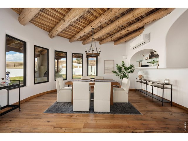 Property Photo 10 A stunning dining space with rustic wood beams, abundant natural light, and seamless flow, perfect for gathering and entertaining in style.