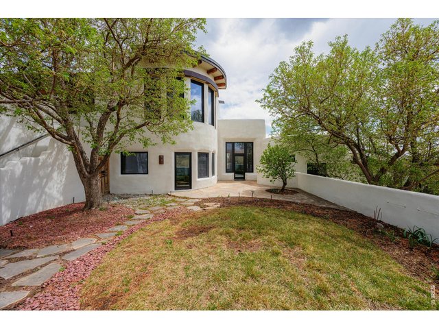 Property Photo 6 A private, tree-lined courtyard offers a serene outdoor retreat with natural shade, stone pathways, and seamless access to the home.