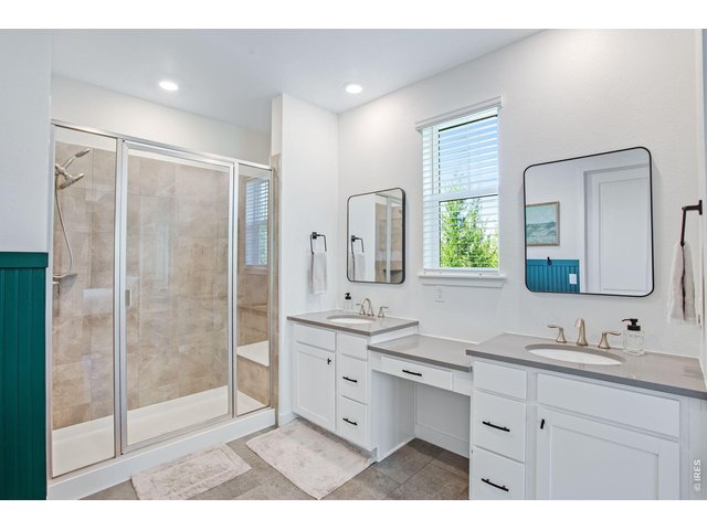 Property Photo 21 Primary ensuite bathroom with dual vanities, upgraded harware, & a walk-in shower with bench seating