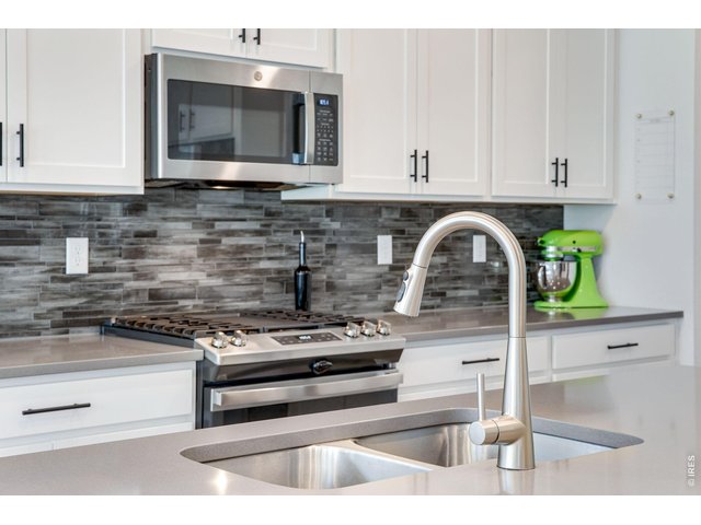 Property Photo 3 custom tiled backsplash, upgraded hardware and gas range