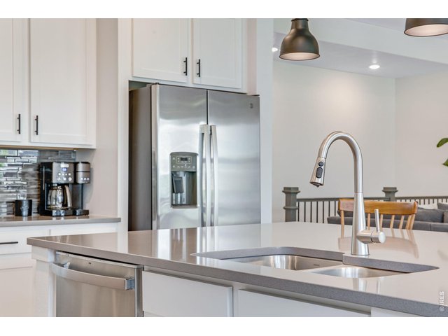 Property Photo 5 oversized kitchen island featuring quartz countertops, dual basin sink, and upgraded pendant lighting