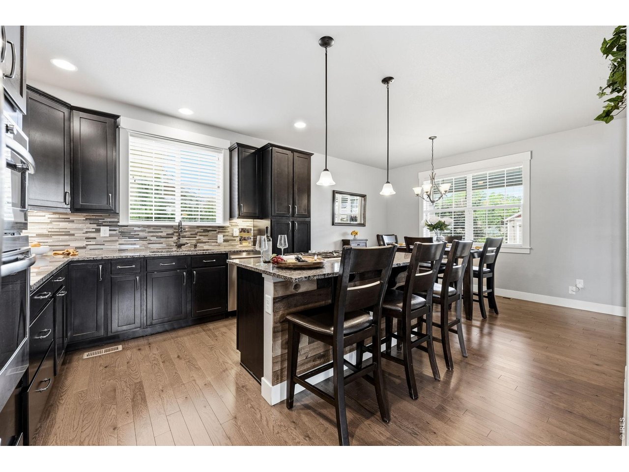The gourmet kitchen is designed for both everyday living and entertaining, featuring a gas cooktop, center island with breakfast bar, ample cabinetry, and dining area.