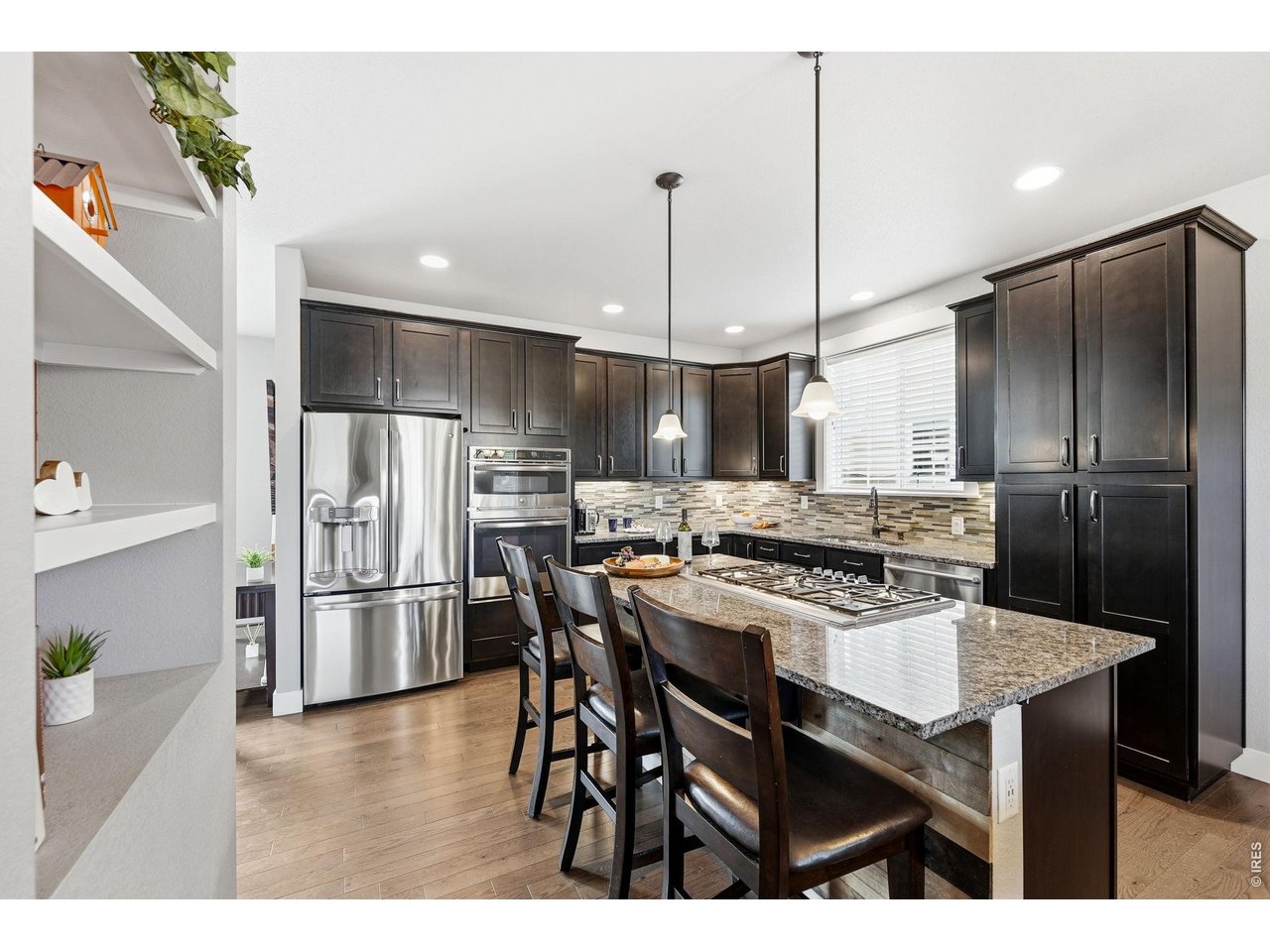 The gourmet kitchen is designed for both everyday living and entertaining, featuring a gas cooktop, center island with breakfast bar, ample cabinetry, and dining area.