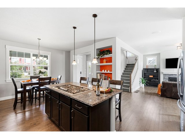 Property Photo 11 The gourmet kitchen is designed for both everyday living and entertaining, featuring a gas cooktop, center island with breakfast bar, ample cabinetry, and dining area.