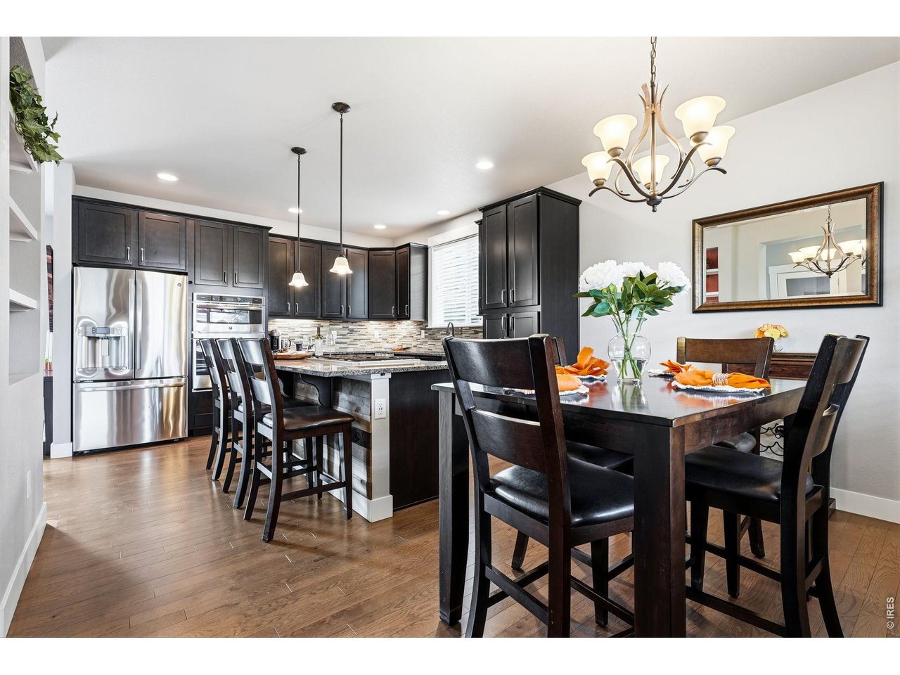 The gourmet kitchen is designed for both everyday living and entertaining, featuring a gas cooktop, center island with breakfast bar, ample cabinetry, and dining area.