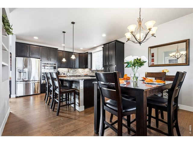 Property Photo 13 The gourmet kitchen is designed for both everyday living and entertaining, featuring a gas cooktop, center island with breakfast bar, ample cabinetry, and dining area.