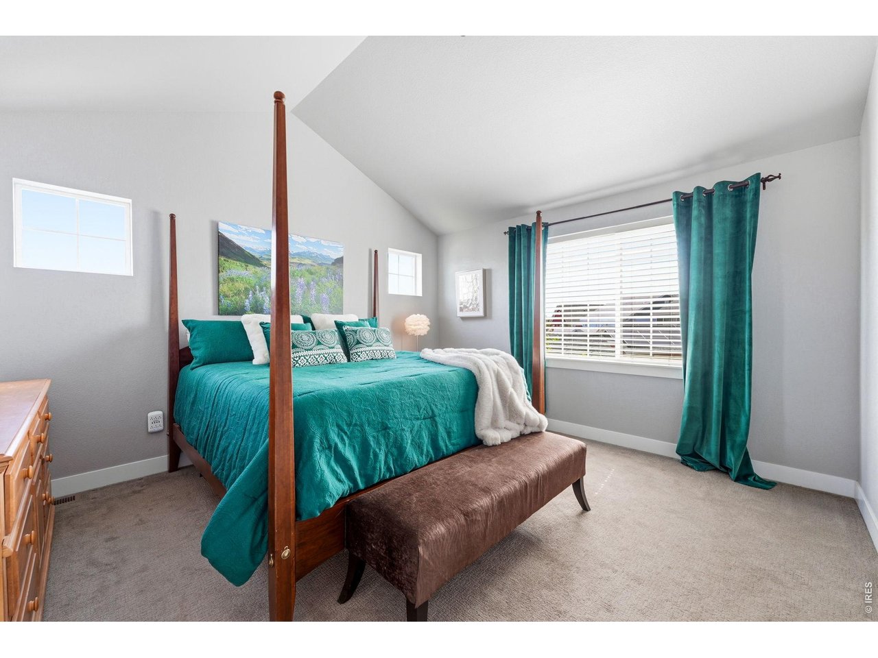 Spacious primary suite boasts vaulted ceilings, a walk-in closet, and a luxurious five-piece bath.