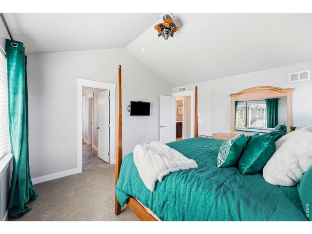 Property Photo 17 Spacious primary suite boasts vaulted ceilings, a walk-in closet, and a luxurious five-piece bath.