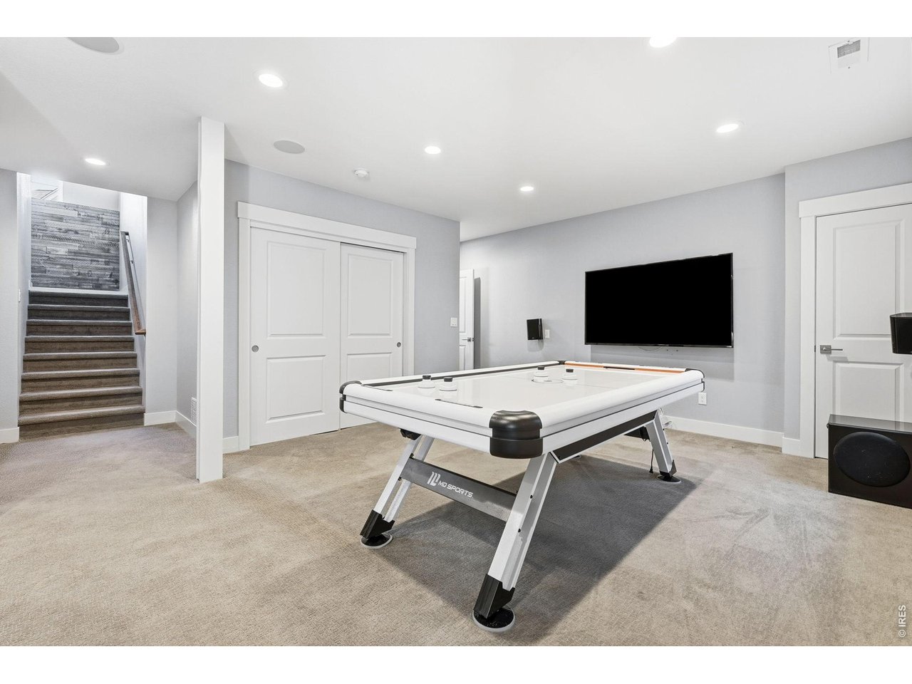 Large recreation room in basement complete with a wet bar, dishwasher, mini refrigerator