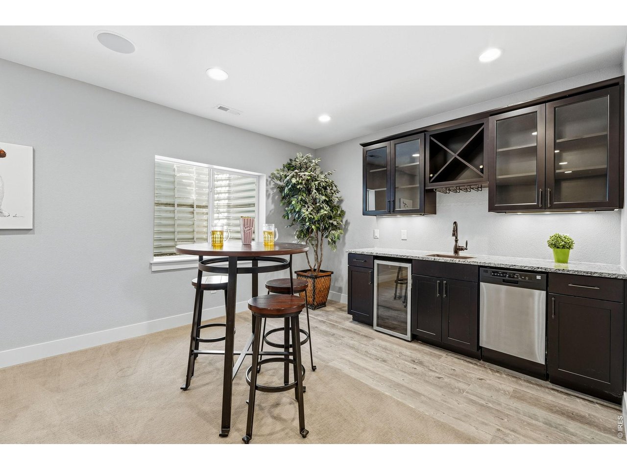 Large recreation room in basement complete with a wet bar, dishwasher, mini refrigerator