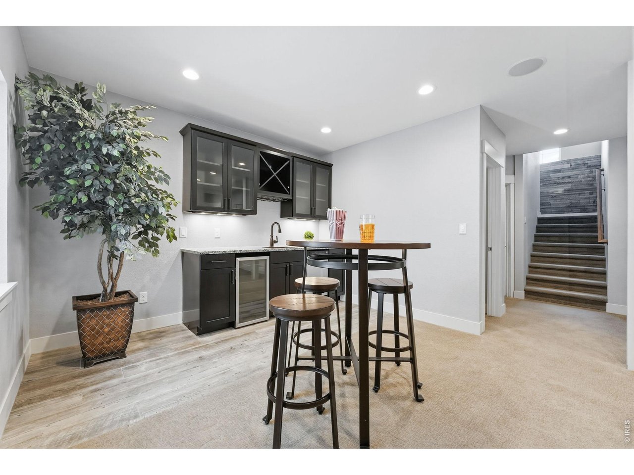 Large recreation room in basement complete with a wet bar, dishwasher, mini refrigerator