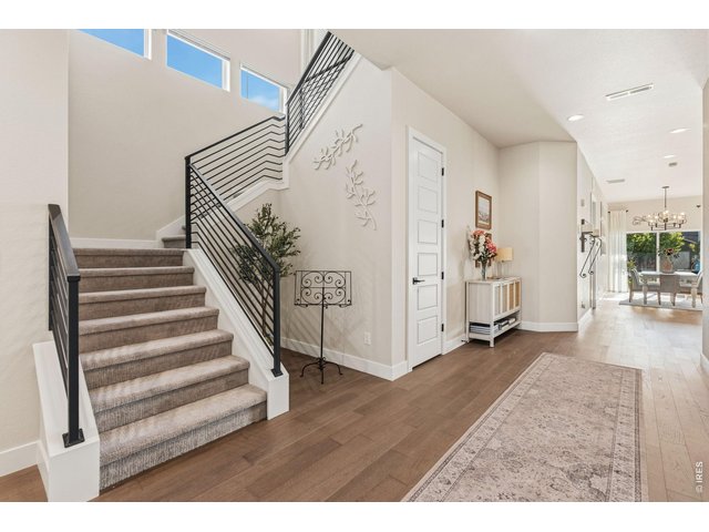 Property Photo 4 Spacious foyer with engineered hardwood flooring and modern finishes welcomes guests.