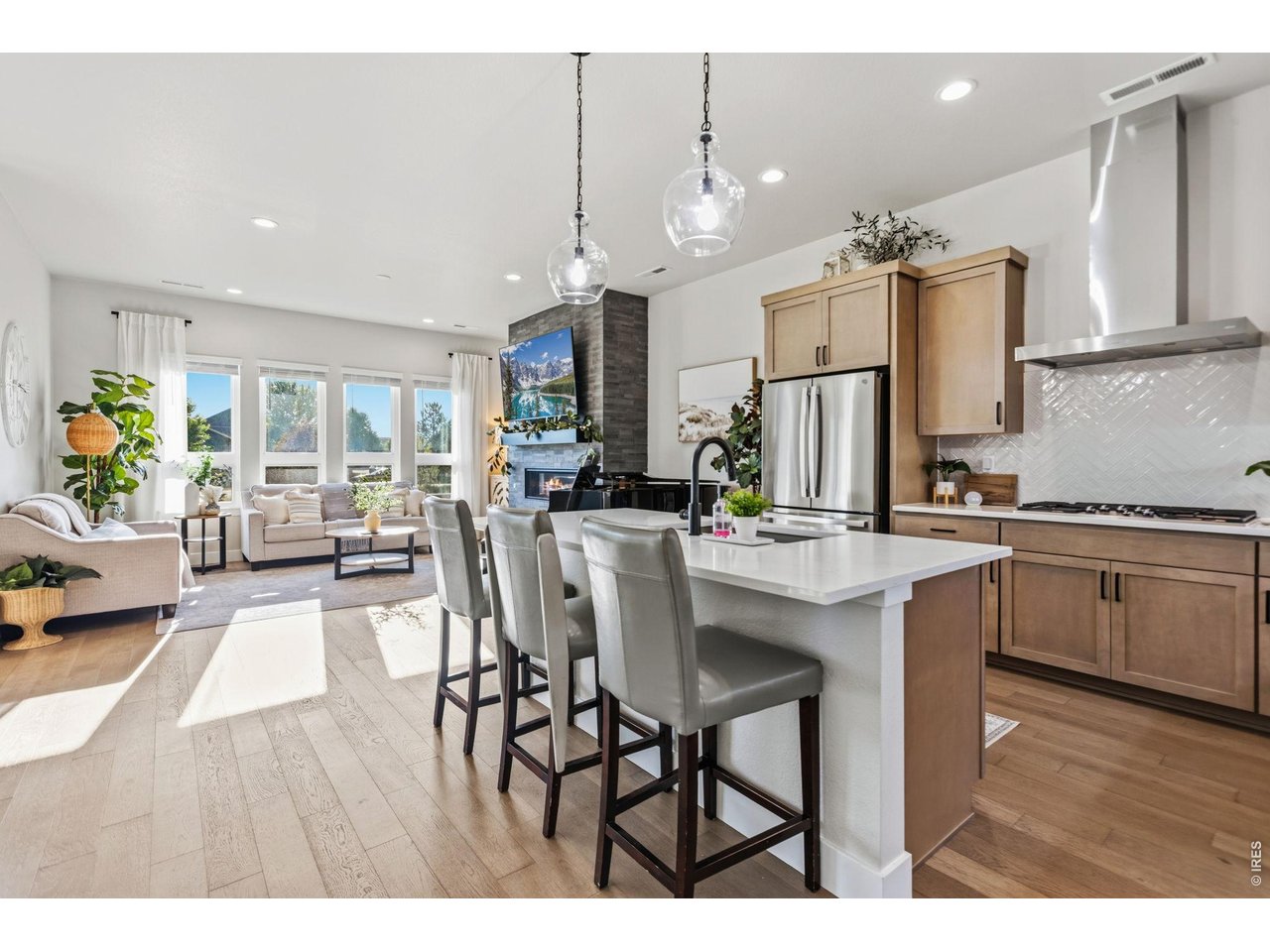 Property Photo 10 Large windows flood the home with natural light throughout the day. Stylish pendant lighting highlights the expansive island. The Zephyr chimney hood adds a sleek designer touch.