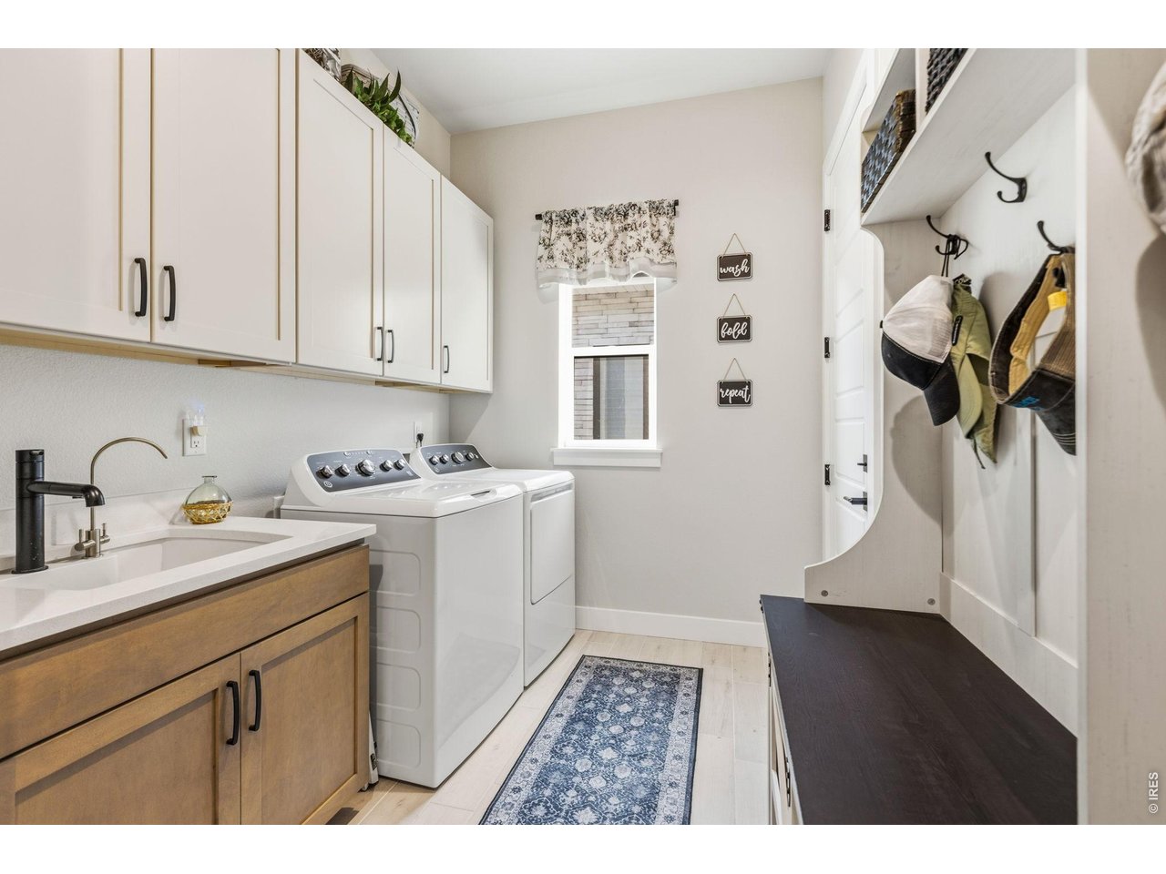 Property Photo 25 Well-appointed laundry room features quartz countertops and utility sink. Added upper cabinetry offers abundant storage.