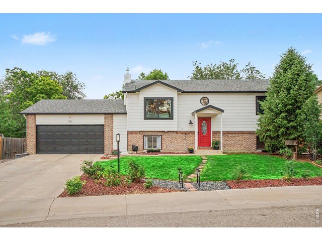 Property Photo 1 Beautifully maintained split-level with a modern facade, iconic red door, and a spacious two-car garage.