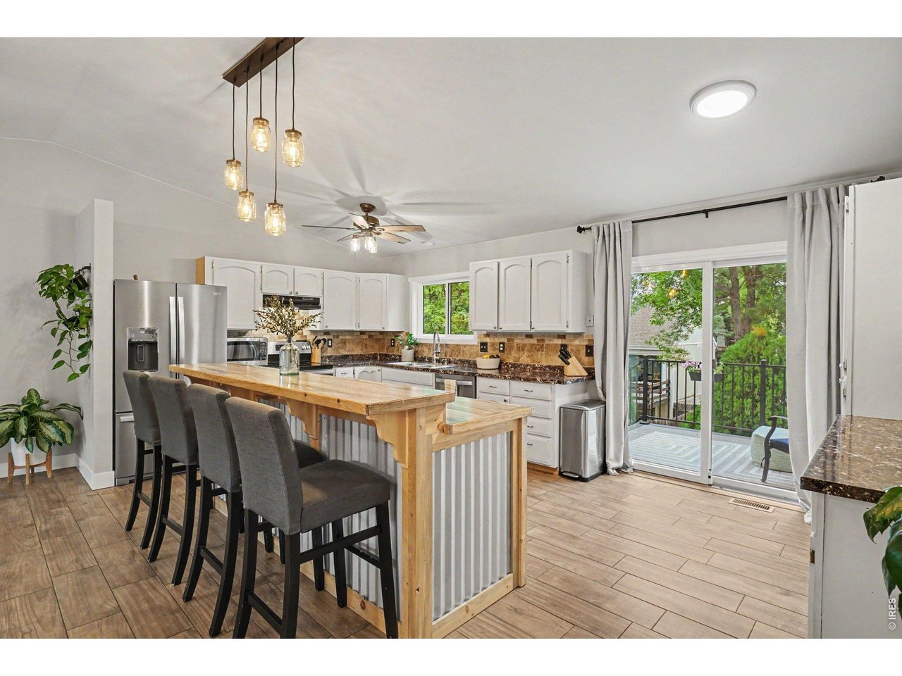 Property Photo 6 Custom island with breakfast bar seating for four, rustic metal accents, and mason jar lighting.