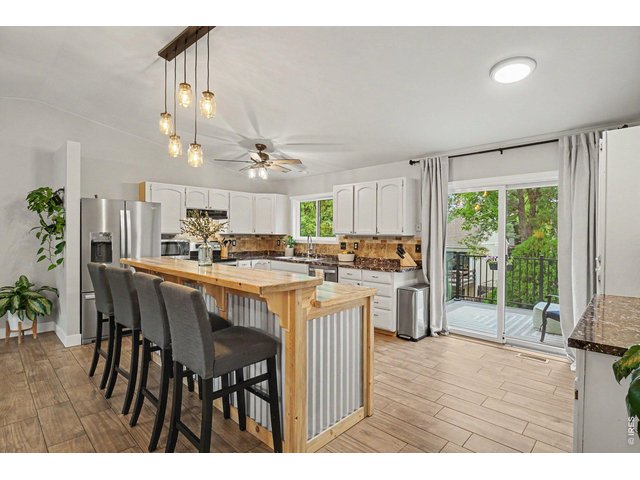Property Photo 6 Custom island with breakfast bar seating for four, rustic metal accents, and mason jar lighting.