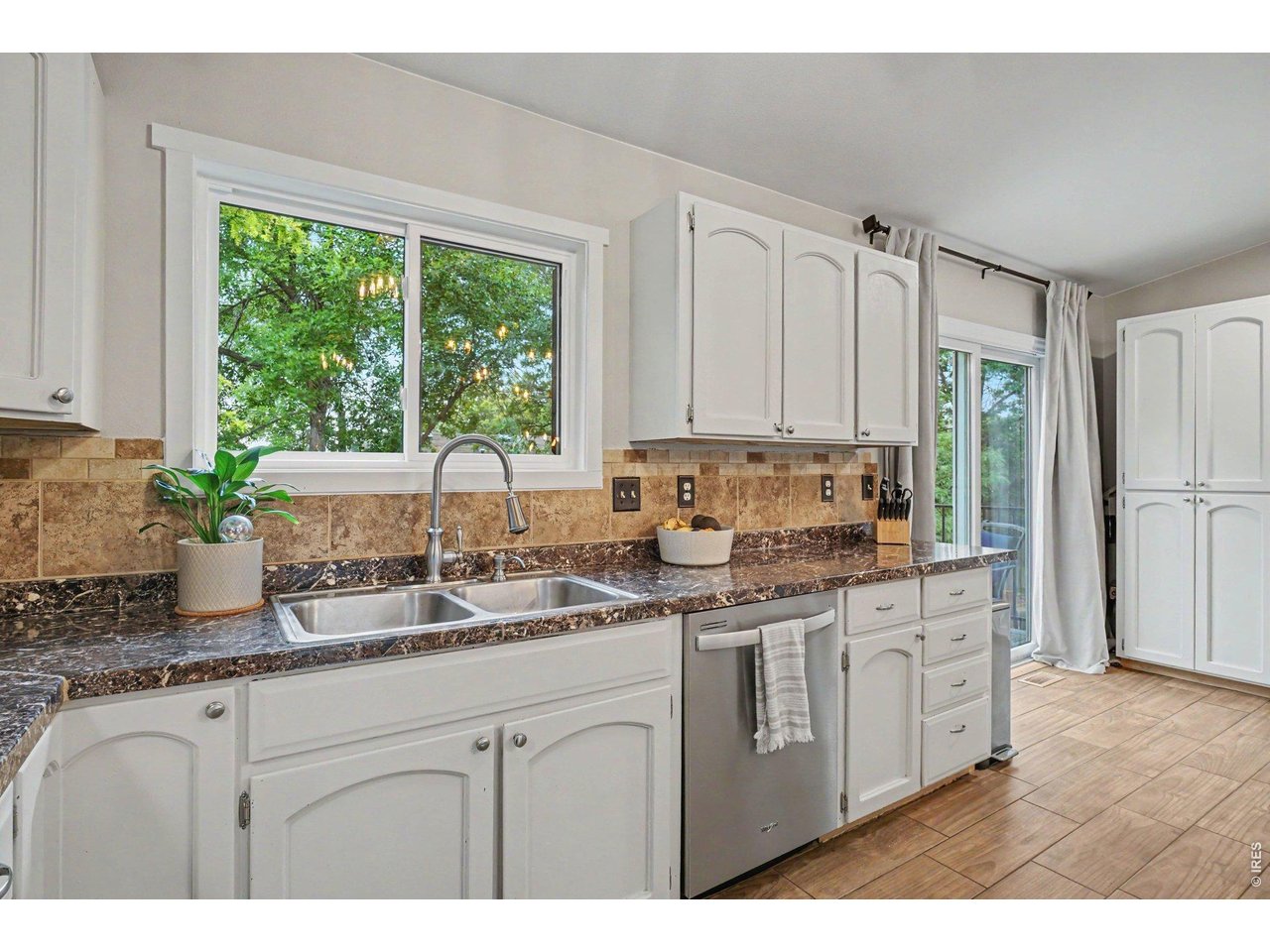 Property Photo 12 Dual-basin stainless sink positioned under a large window with peaceful, tree-lined views.