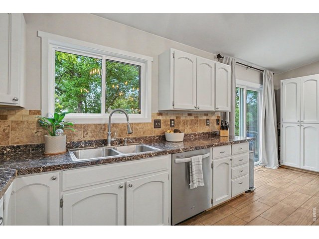 Property Photo 12 Dual-basin stainless sink positioned under a large window with peaceful, tree-lined views.