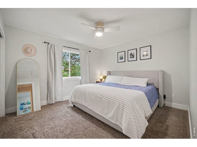 Property Photo 13 Primary bedroom layout highlighted by a bright window, clean finishes, and ample space for a full suite of furniture.