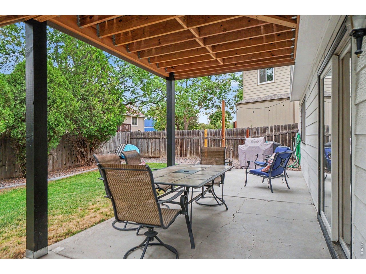 Property Photo 30 Expansive concrete lower patio sheltered by the deck above, creating an ideal shade-protected spot for outdoor dining and entertaining next to the lawn.