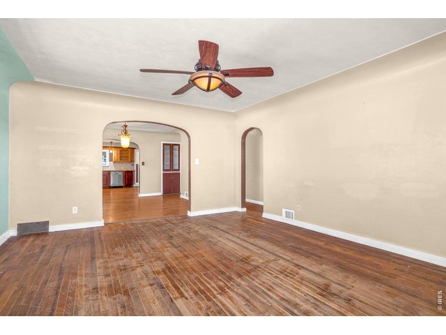 Property Photo 8 Living room with original hardwood flooring.